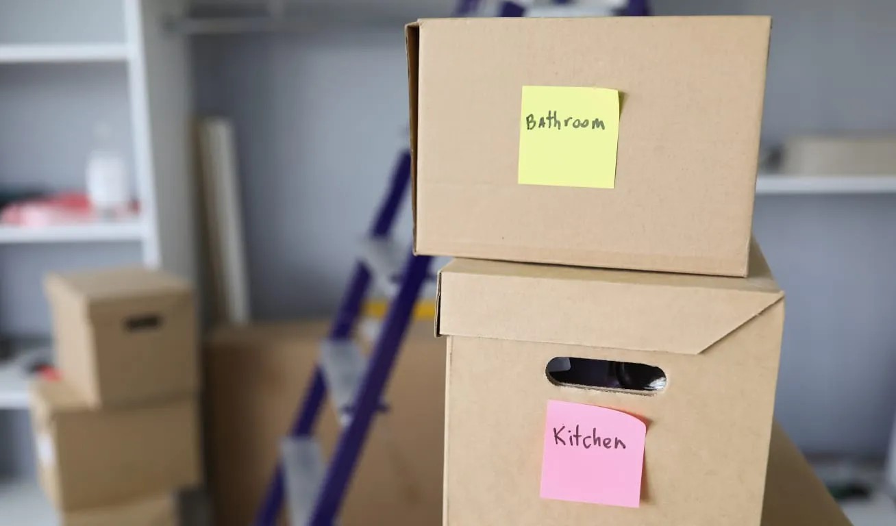 Moving Day - Organized Packing Cardboard boxes with labels for bathroom and kitchen items